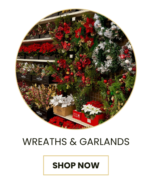 A promotional graphic featuring a circular photo of a holiday floral display with red poinsettias, green garlands, and white snowflake decorations on shelves. Below the photo, the text reads 'WREATHS & GARLANDS' above a 'SHOP NOW' button on a white background.